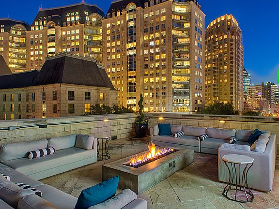 Luxury rooftop lounge with firepit and Uptown Dallas views