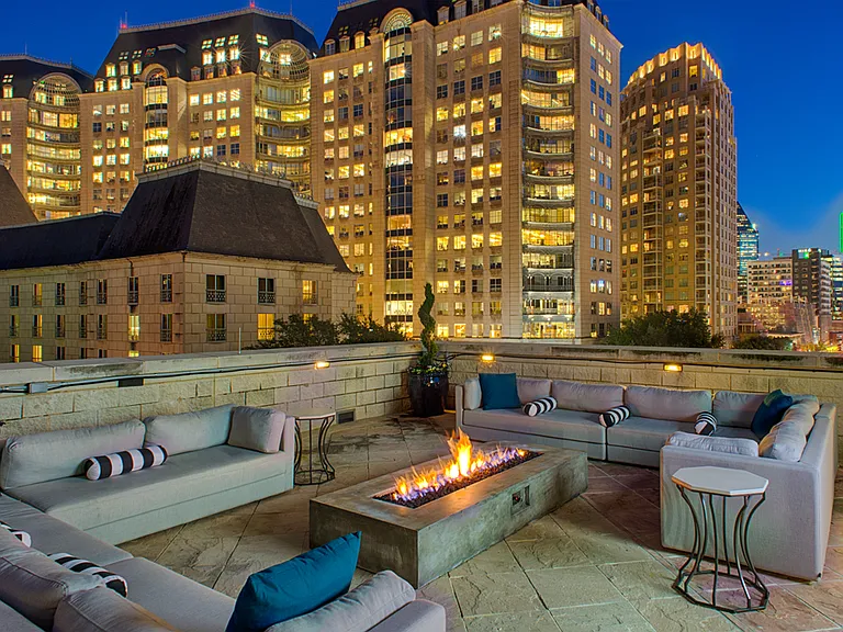 Luxury rooftop lounge with firepit and Uptown Dallas views