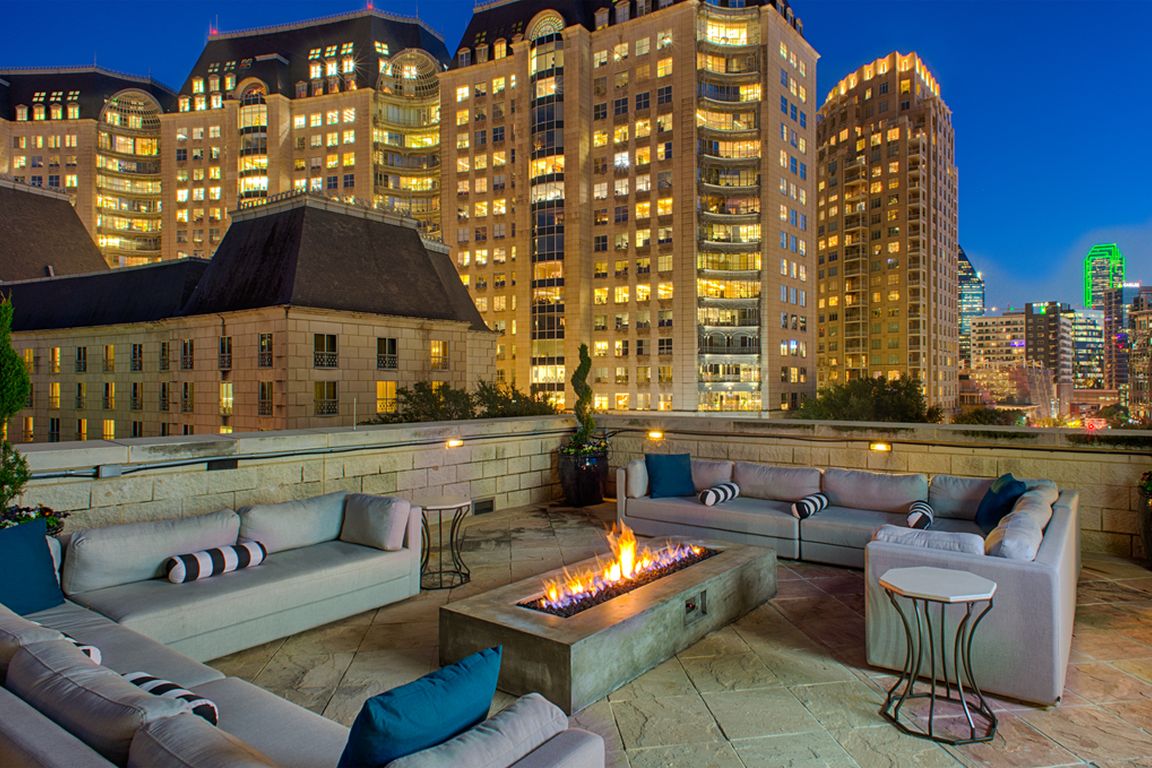 Luxury rooftop lounge with firepit and Uptown Dallas views