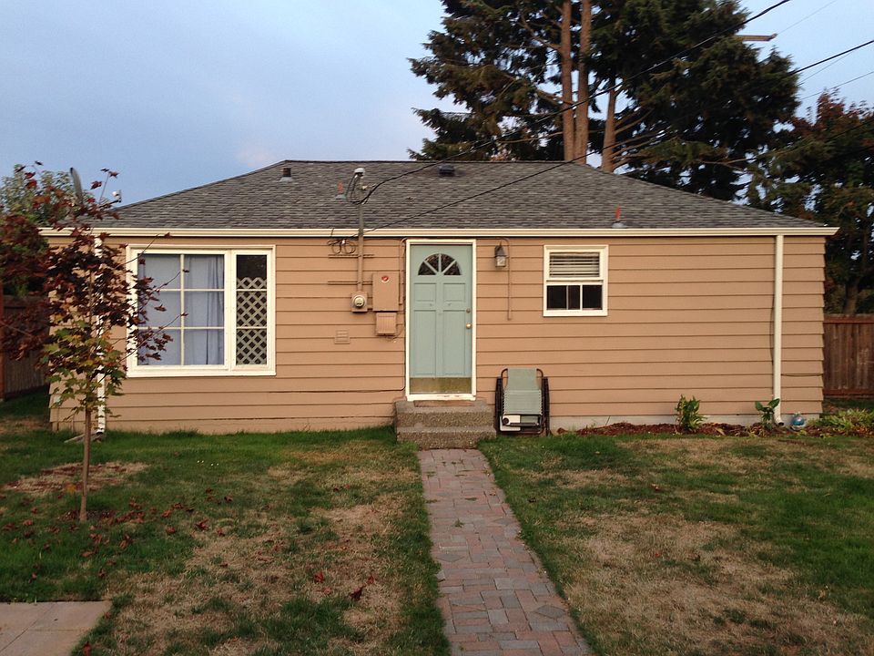 Fully fenced back yard with garden space. sidewalk leads to