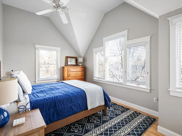 Left front bedroom with queen bed, vaulted ceiling, large closet, ceiling fan, and view of the ocean.