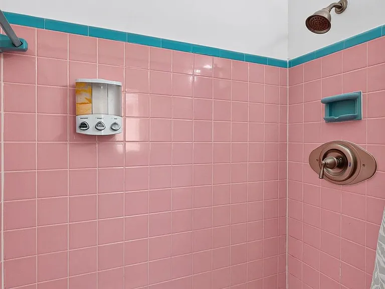 Walk-in tiled shower with built-in soap dish and sturdy fixtures, offering an easy-to-clean, practical bathing space.