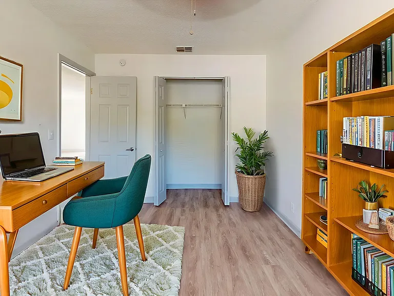 Cozy home office with stylish wooden desk, elegant chair, and vibrant bookshelf, ideal for productivity and inspiration.