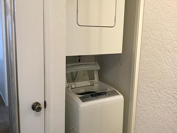 Laundry located at end of hall next to bathroom.