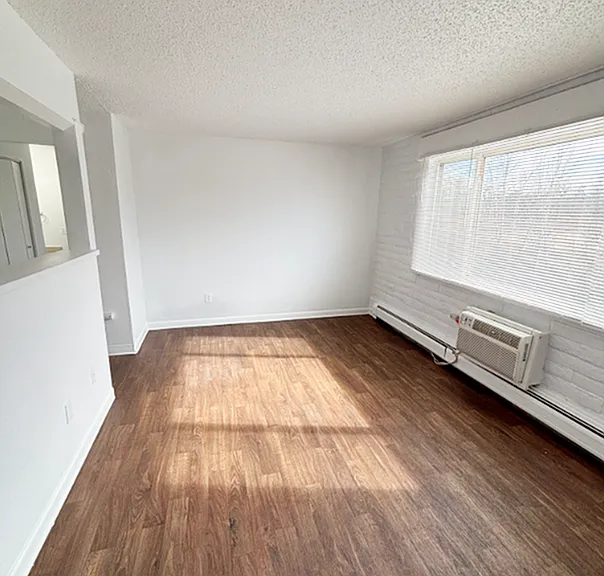 Bright, open living space with elegant wood flooring and large windows providing abundant natural light.