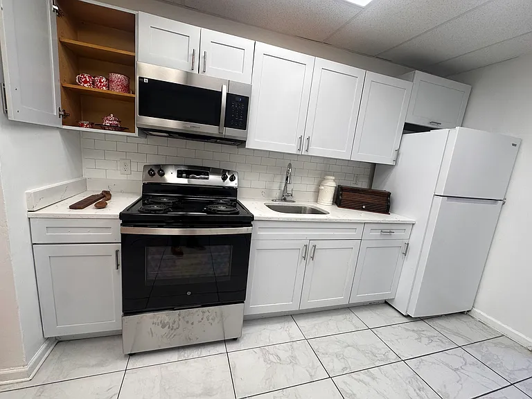 Fresh white kitchen with a brand-new stove and modern appliances.