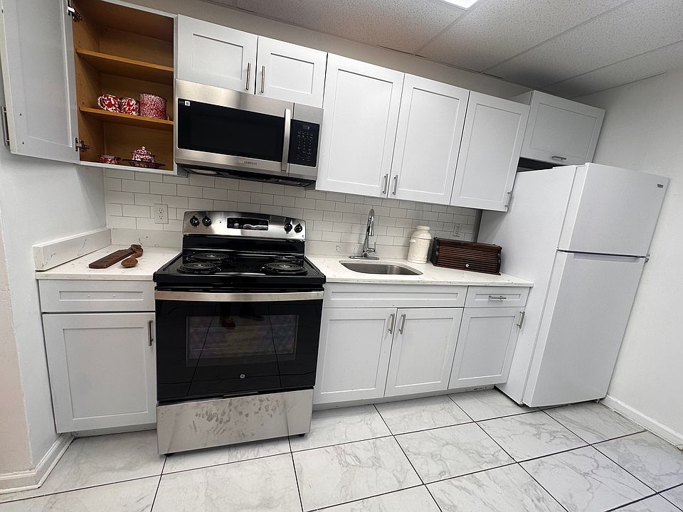 Fresh white kitchen with a brand-new stove and modern appliances.