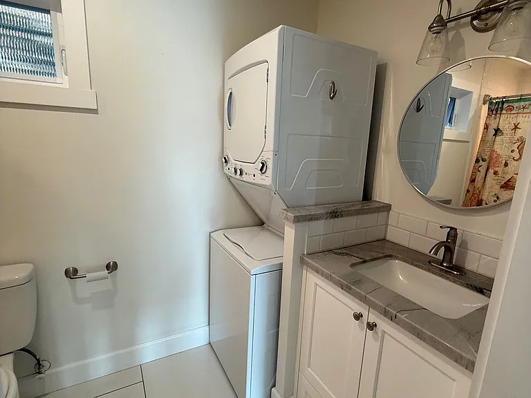 In unit washer & dryer with modern vanity and stone countertop