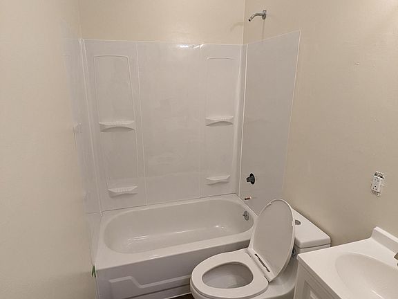 Bright new fixtures, flooring same as ktichen. Finishing touches in work; medicine cabinet/mirror in front of vanity, storage over toilet, and towel/ toilet paper bars being added.