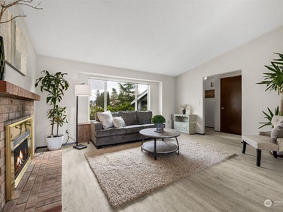 A cozy fireplace and new vinyl plank flooring are attractive additions to this space. >