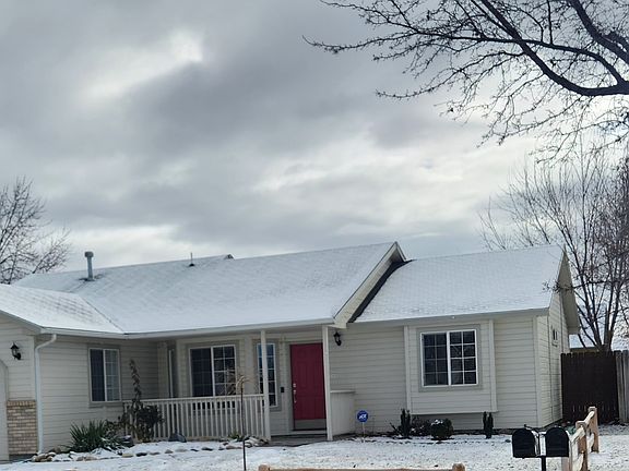 Adorable red door and welcoming small wood fence.
