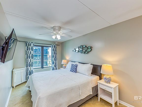Tiled bedroom featuring ceiling fan