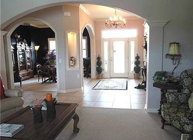 Great Room. Notice the architectural design...arched doorways, tray ceiling, columns, built-ins, and curved corners.  Custom curtains will remain with the home.