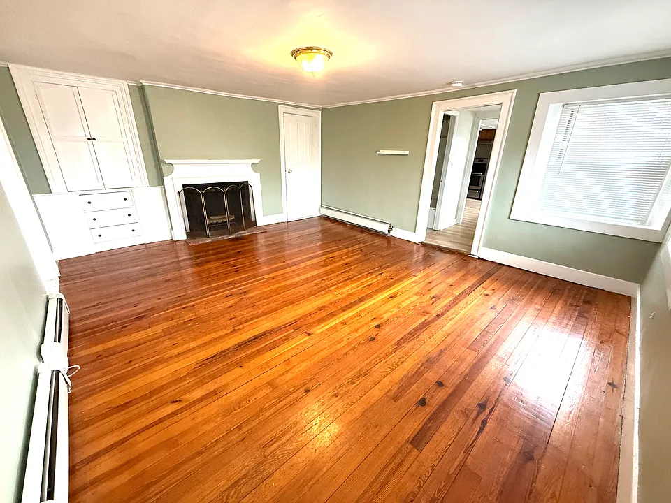 Large living room with fireplace, built-in and generous natural light.