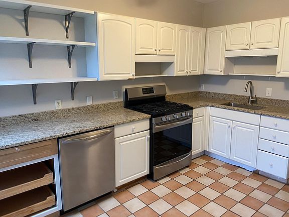 Updated kitchen with stainless appliances, granite countertops, and custom open shelving