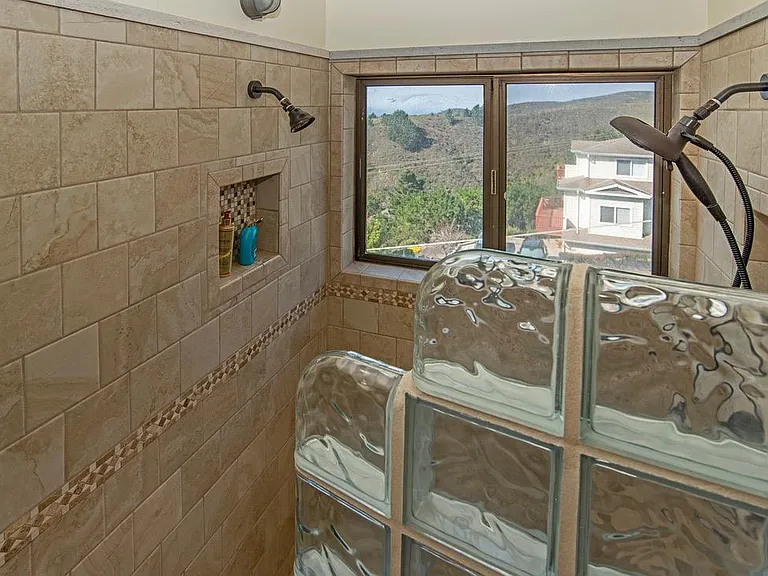 Curved glass block shower wall with dual shower heads-view of ocean, general aviation airport & hills