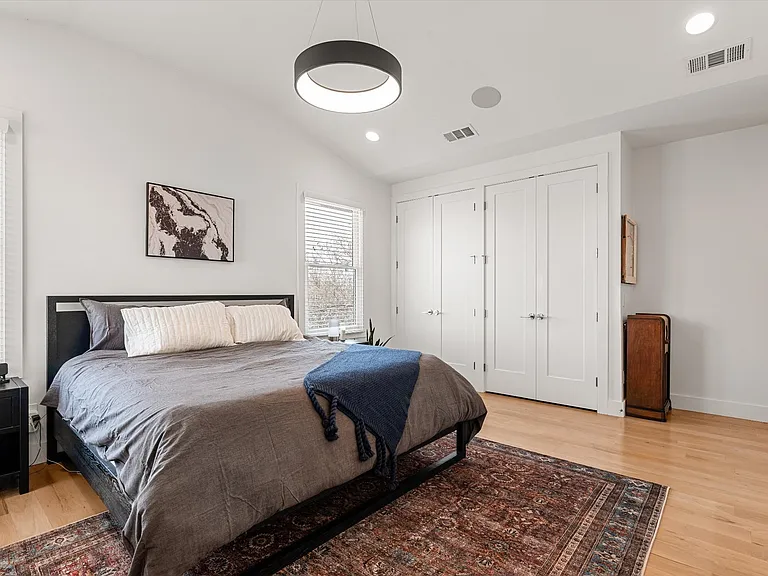 Spacious primary suite filled with natural light and hardwood floors.