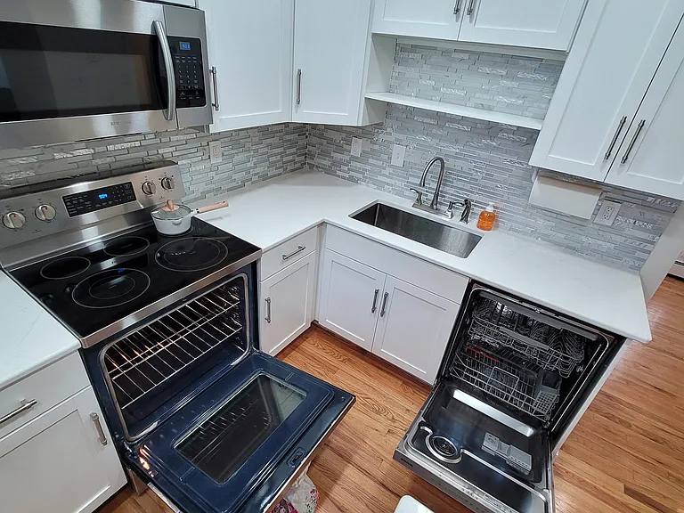 hardwood floors, garbage disposal, and stainless steel dishwasher, built-in microwave, electric stove, & oven