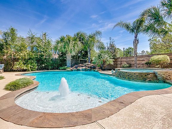 Enjoy this exceptional view year round from either covered patio! There were no details spared with this stunning pool - highlighting the beautiful fountains and lush landscaping behind.