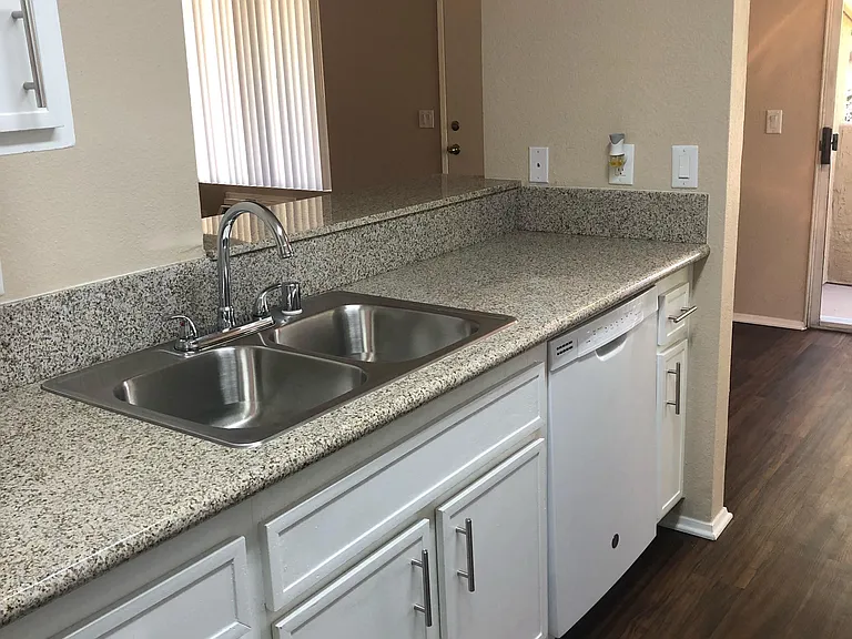 Open kitchen view into living room and dining room, poarch areas at Grande Vista Apartments.