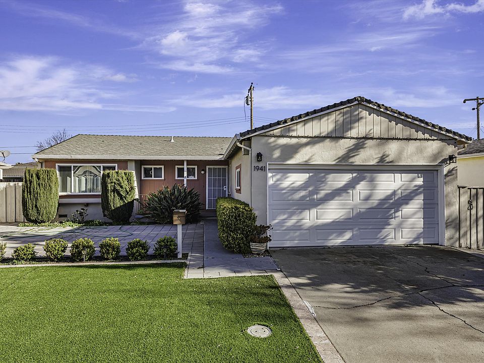 The front yard is covered with artificial grass, requiring little to no maintenance.