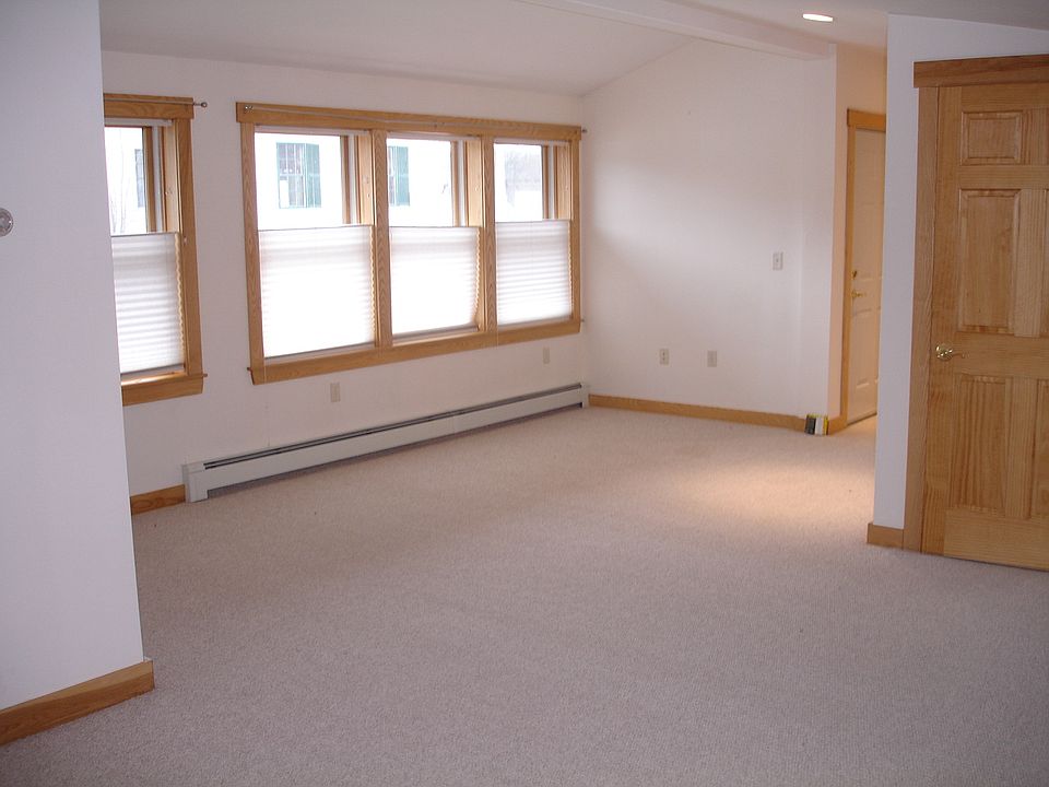 Partial view of the large, south-facing living area. Entrance door to the left rear and bedroom door to the right.Note honey-comb blinds may be lowered from the top.