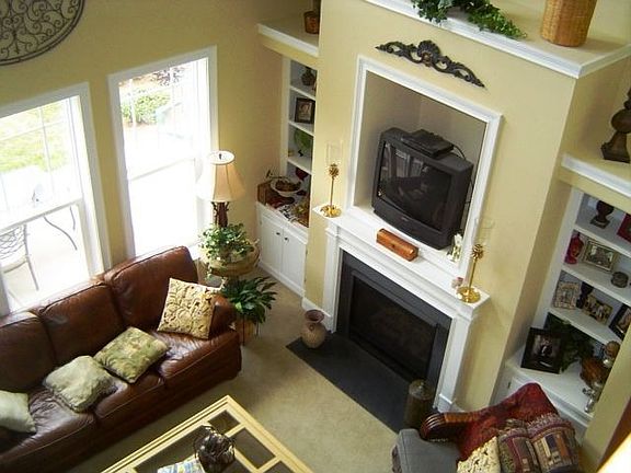 -Story family room with built-in bookshelves, gas fireplace,ceiling fan and up
