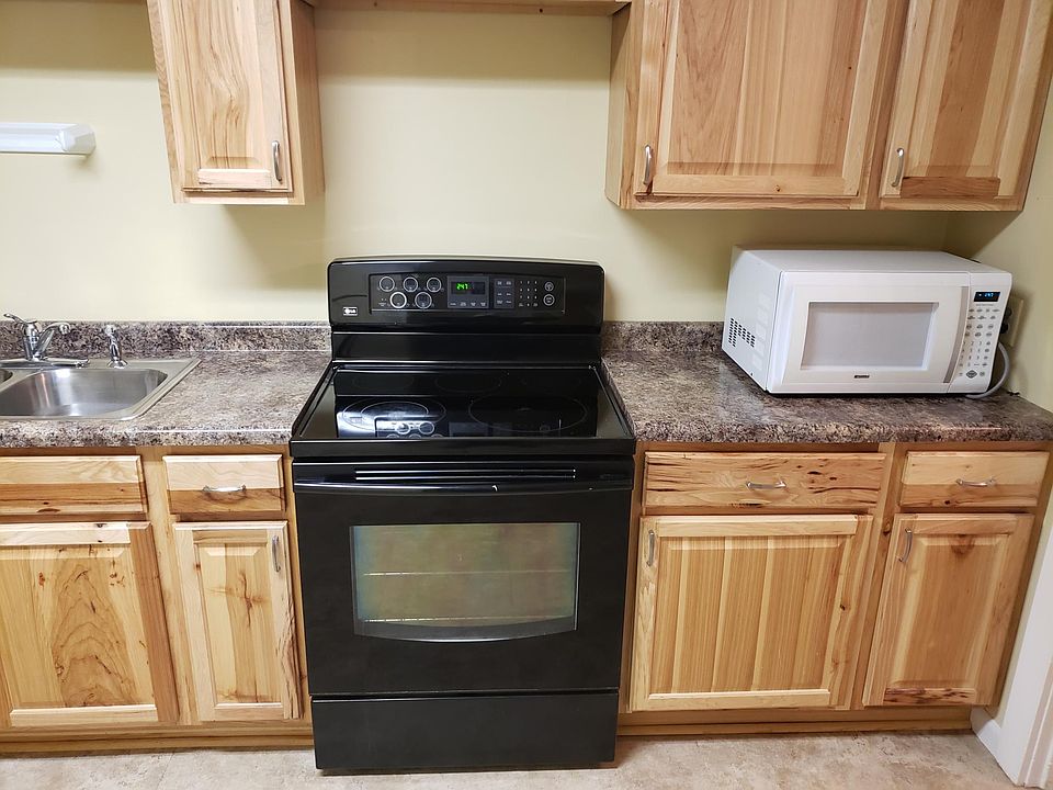 Bright new kitchen with stainless fridge and glass top range