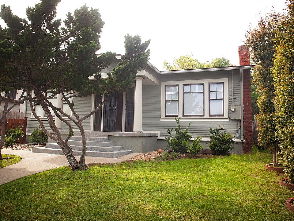 Exterior with with new redwood fencing, lawn and landscaping, large porch