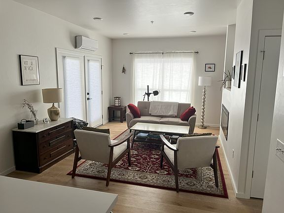 Living room view (blinds and sheer curtains, flush electric fireplace, and door to patio).
