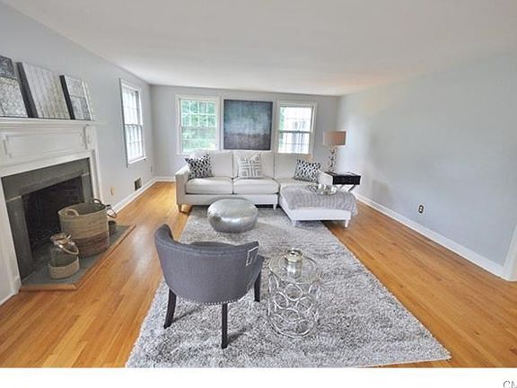 Spacious, sunlit formal living room with wood burning fireplace.