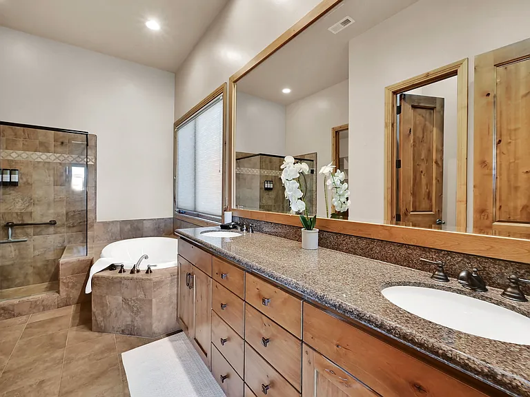 Master bathroom with his and hers sink, large tub and walk in shower. Also has separate toilet room