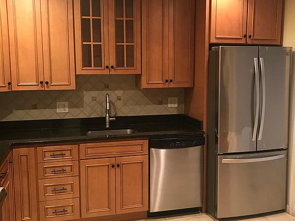 Kitchen with granite countertop, under cabinet lights and stainless steel appliances