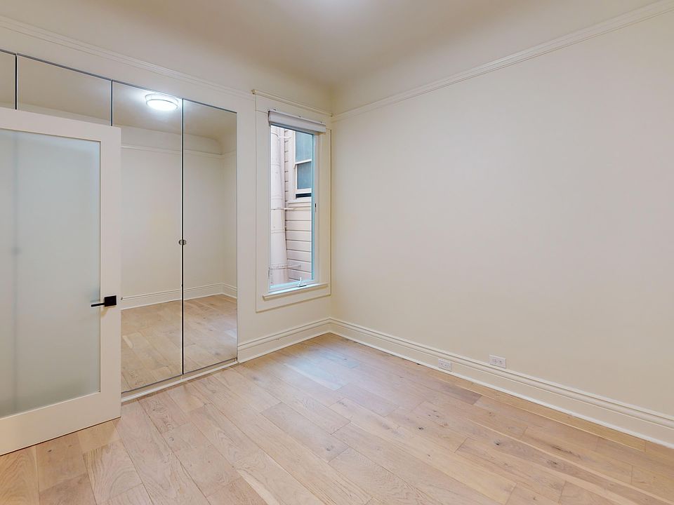 Bright bedroom with wood-like floor and a closet with mirror
