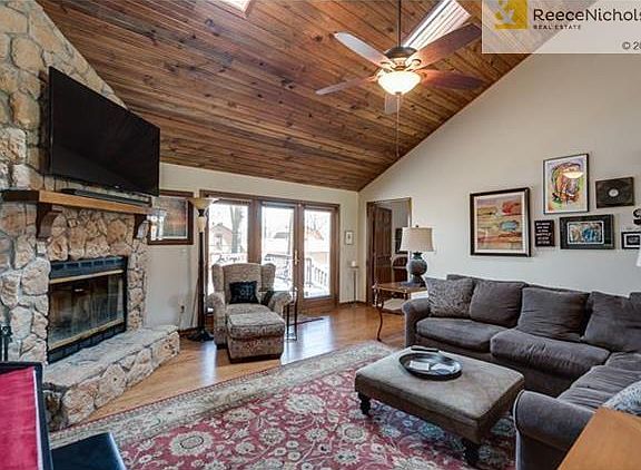 Greatroom with vaulted ceiling and corner stone fireplace; hardwood floors throughout common area.
