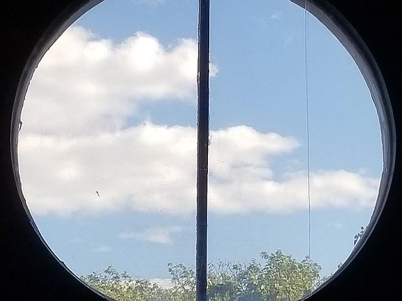 distant view through ~6 ft circular window from interior balcony