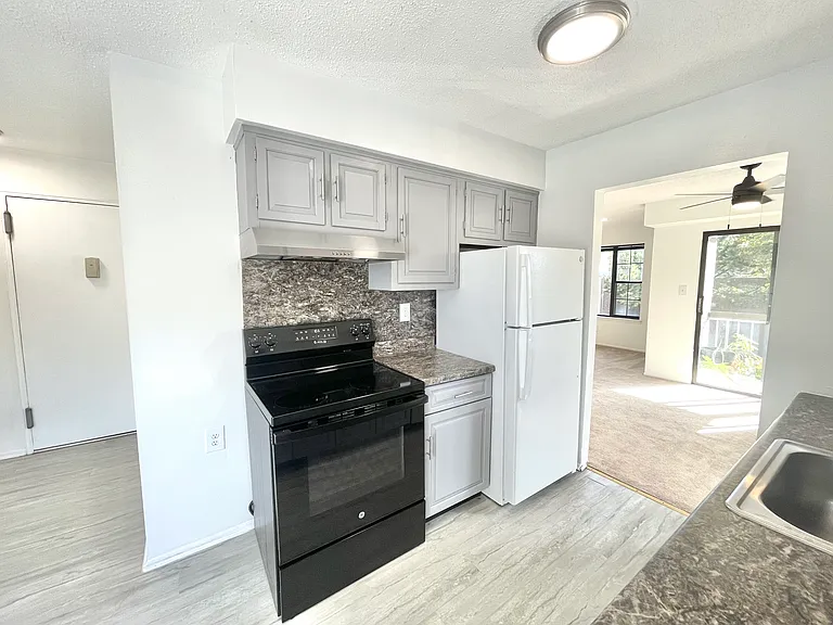 Entry door to the left, walkthrough kitchen with a view of the dining area