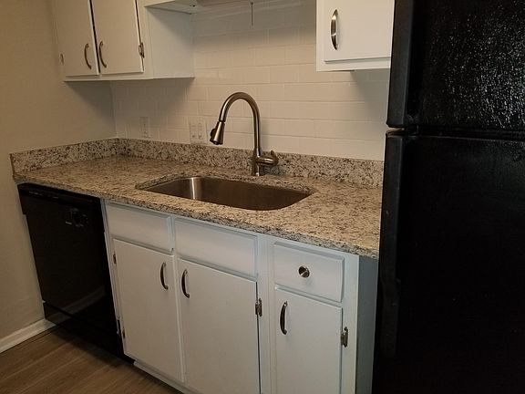 Galley kitchen with lots of cabinets and granite counter-top