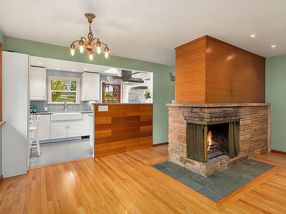 Hardwood floors throughout with an open floor plan in the living room, dining and kitchen area. Upon entering, you'll be greeted with all the original mid-century charm including a corner fireplace and warm wood details.