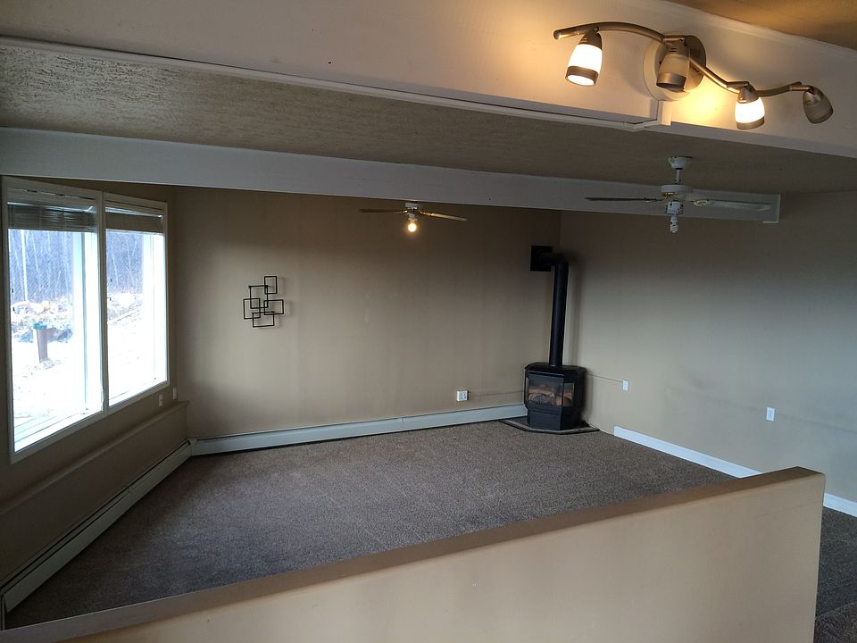 Living room with gas fireplace, plenty of windows.