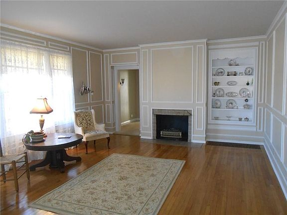 Stunning wood floors, built ins and eye catching elegant paint and trim add and excellent stylish note to the formal living room.  The home has four fireplaces.  This is fireplace one