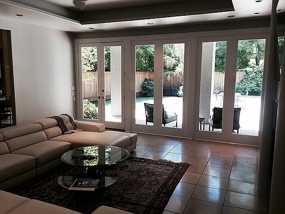 Another view of the living room leading to the covered patio and the backyard and with an open view 