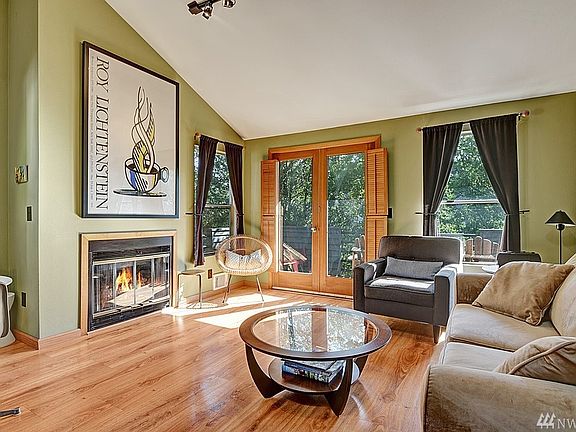 Spacious Living room with wood burning fireplace and vaulted ceilings..