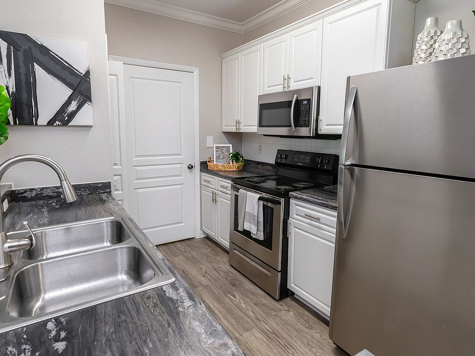 Cook, clean, and entertain with ease in this fully equipped kitchen,featuring stainless-steel appliances, white shaker cabinets, and wood-style flooring.