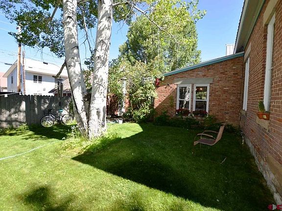 Fenced back yard, manicured lawn and mature trees.  Access to the detached garage and alley.