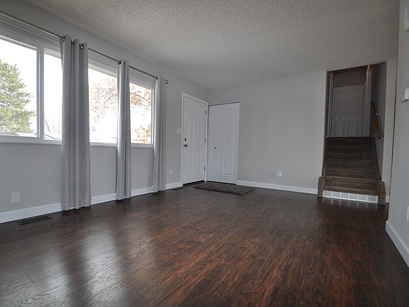 Another view of the living room showing stairs leading up to upper-level bedrooms and a full bath.