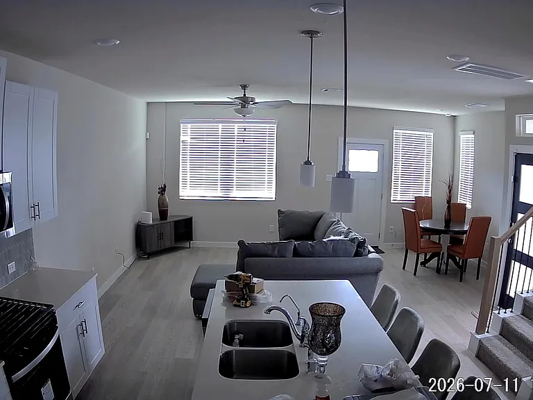 Open-concept kitchen with island seating flows into the living area and dining nook, offering ample cabinet space and natural