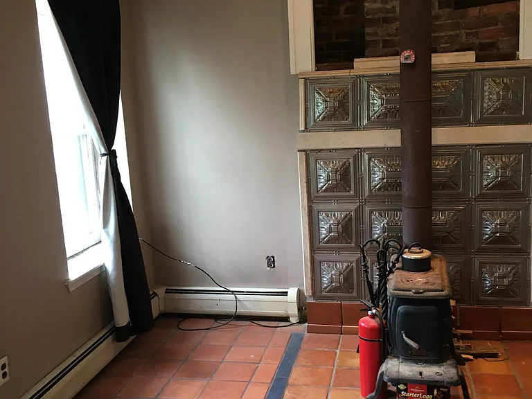 living room with wood stove and window to the back yard