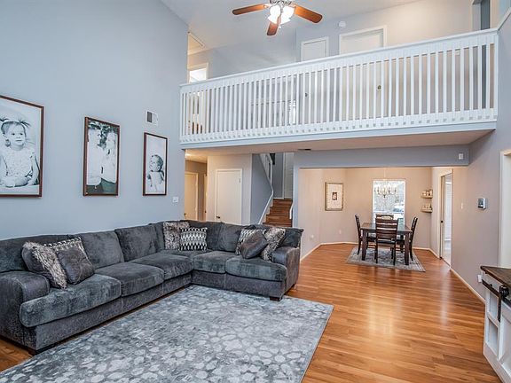 Vaulted family room, laminate wood flooring, ceiling fan, crisp white trim and paint is right on trend.