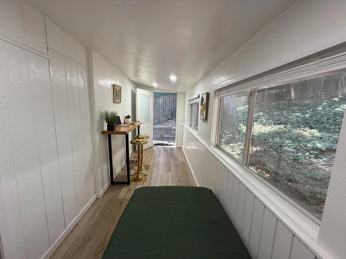 Photo 2 of 10 - State Highway 138 - Crestline, CA Narrow bedroom with a daybed, compact work bar, and large windows providing wooded views and ample daylight. - State Highway 138